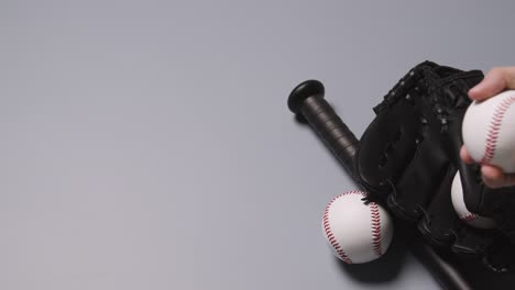 Overhead-Baseball-Still-Life-With-Bat-And-Catchers-Mitt-With-Person-Picking-Up-Ball